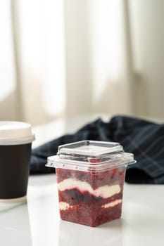 Trifle red velvet in plastic cup on table close up