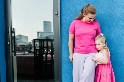 Child girl with cochlear implant with her mother spend time outdoor. Hear impairment and deaf community concept. Deaf and health concept. Diversity and inclusion. Copy space.