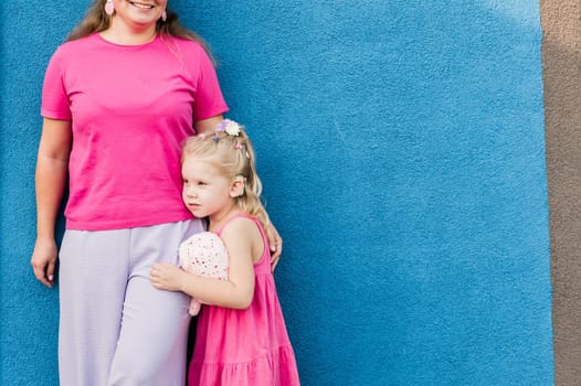 Deaf child with cochlear implant for hearing audio and aid for impairment having fun and laughs with mother outdoor in summer. Sound fitting device to help with communication listening and interaction.