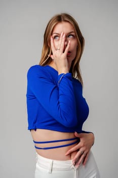 Young Woman model in Blue Top and White Pants posing on white background in studio