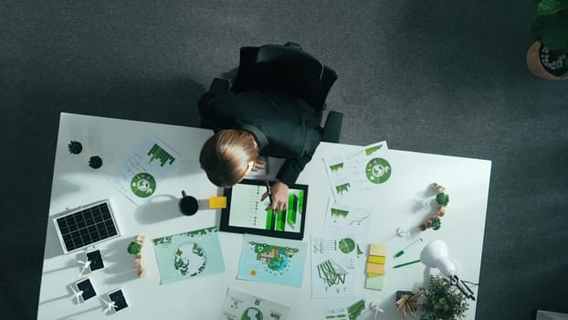 Top view of smart manager making decision about green business investment. Aerial view of skilled business woman working at meeting table with document about green energy and zero waste. Alimentation.