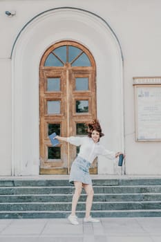 Woman staircase city. A business woman in a white shirt and denim skirt walks down the steps of an ancient building in the city.