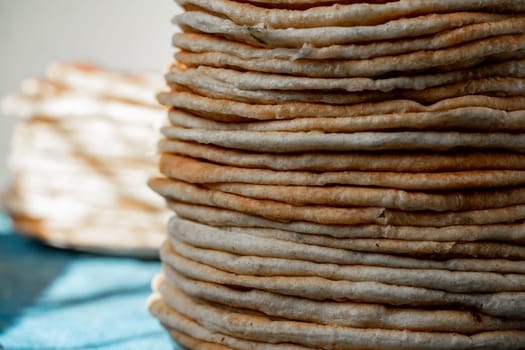 Flatbread lavash, chapati, naan, heap of tortilla on a blue background Homemade flatbread stacked