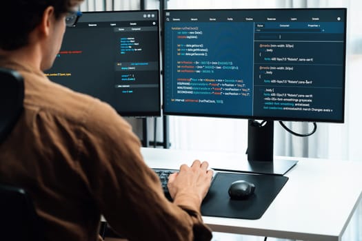 IT developer working online software development on pc monitors at modern home office on coding application screens, creating updated latest program firmware information version concept. Gusher.
