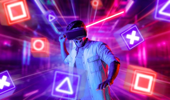 Energetic man with VR glasses fencing neon sword with music block. Skilled person playing a game while holding sword and enter in metaverse with neon city background. Blurring background. Deviation.