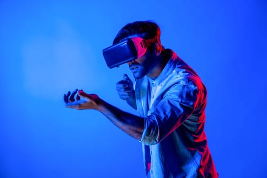 Side view of man wearing VR glass and moving gesture holding gun. Gamer using future digital virtual reality headset or futuristic innovation to enter meta world or playing action game. Deviation.