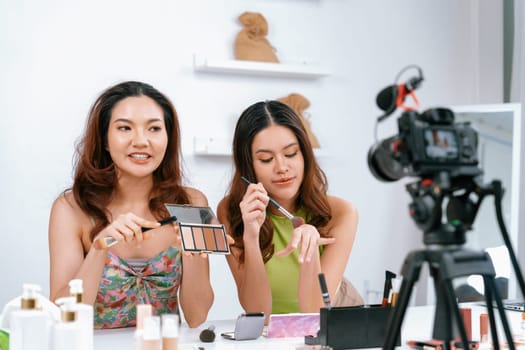 Woman influencer shoot live streaming vlog video review makeup uttermost social media or blog. Happy young girl with cosmetics studio lighting for marketing recording session broadcasting online.