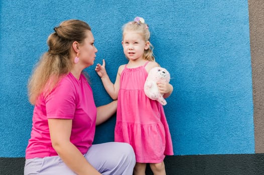 Child girl with cochlear implant with her mother spend time outdoor. Hear impairment and deaf community concept. Deaf and health concept. Diversity and inclusion. Copy space.