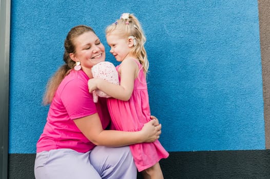 Deaf child with cochlear implant for hearing audio and aid for impairment having fun and laughs with mother outdoor in summer. Sound fitting device to help with communication listening and interaction.