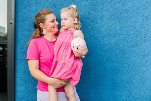 Deaf child with cochlear implant for hearing audio and aid for impairment having fun and laughs with mother outdoor in summer. Sound fitting device to help with communication listening and interaction.