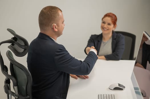 Business partners shake hands while concluding a deal. Deaf business man
