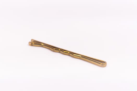 Small gold black metal hairpin isolated on a white background closeup