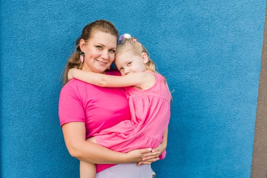 Deaf child with cochlear implant for hearing audio and aid for impairment having fun and laughs with mother outdoor in summer. Sound fitting device to help with communication listening and interaction.