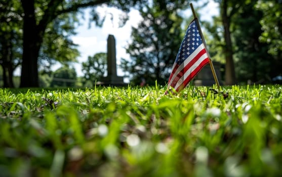 Sunlight filters through trees onto an American flag in a cemetery, honoring veterans on a somber Memorial Day