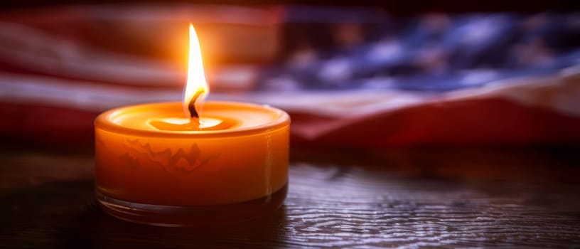 An ornate, flag-patterned candle burns brightly, its flickering flame a symbol of the enduring spirit and sacrifice of those honored on Memorial Day