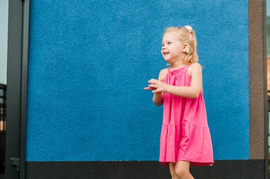 Child girl walks and have fun outdoor with cochlear implant on the head. Hearing aid and treatment concept. Copy space vertical.