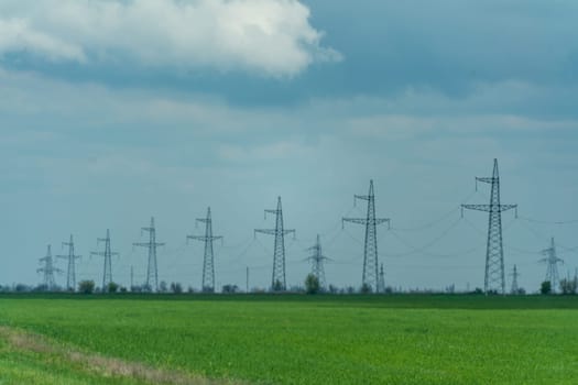 High voltage towers with sky background. Power line support with wires for electricity transmission. High voltage grid tower with wire cable at distribution station. Energy industry, energy saving.