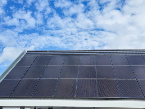 A modern solar panel, glinting in the sunlight, harnessing renewable energy on the rooftop of a building. solar panels attached on a roof of a new house in the Netherlands