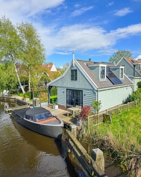 A boat peacefully sits in the calm water of a serene lake, reflecting the beauty of its surroundings. wooden facades and old houses in Broek in Waterland in the Netherlands