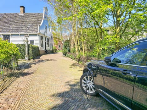 An electric EV car is elegantly parked in front of a charming house, contrasting the modern with the traditional in the Netherlands