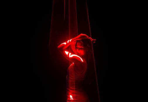 Beautiful woman dancing under red illumination, laser light, neon party night club. Projection mapping. Interactive exposition installation. High quality photo
