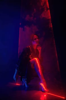 Gorgeous woman in latex coat under colorful illumination, laser light, neon smoke club. Projection illusion mapping. Futuristic model. High quality