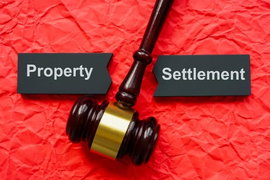 Property settlement concept. Split dark tablet and gavel on crumpled paper.