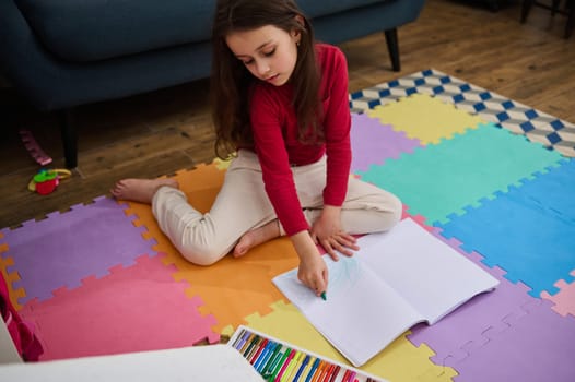 Portrait of a talented little child girl drawing picture at home. Arts and cultures. Hobbies and leisure. Kids education concept