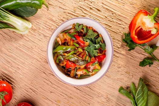 Stir-fried veggies with peppers, onions, and tomatoes, cooked perfectly. Served in a white bowl, ready to enjoy.