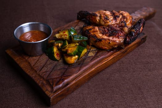 Juicy grilled chicken with crispy skin, fresh cucumber, and spicy sauce. A delectable meal for any occasion.