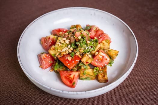 warm eggplant and tomato salad with nuts in the cafe.