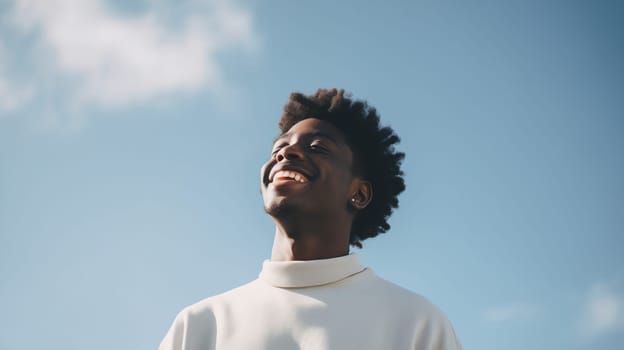 Portrait of inspired stylish happy smiling black american young man enjoys the sunlight and fresh air, peaceful moment outdoors on a summer day against a blue sky background