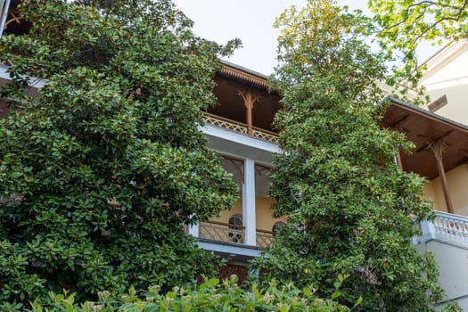 A building with a balcony and a tree in front of it