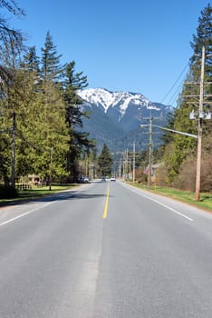 Street in small town in Canada with bluesky and snow top mountain as the background