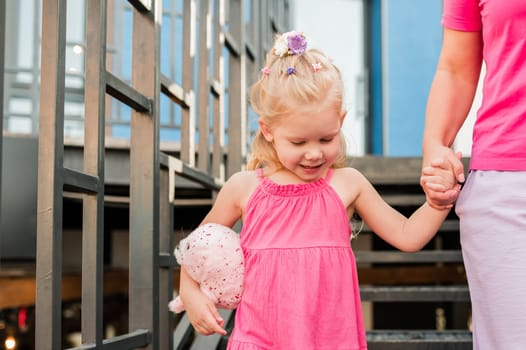 Child girl walks and have fun outdoor with cochlear implant on the head. Hearing aid and treatment concept. Copy space vertical.