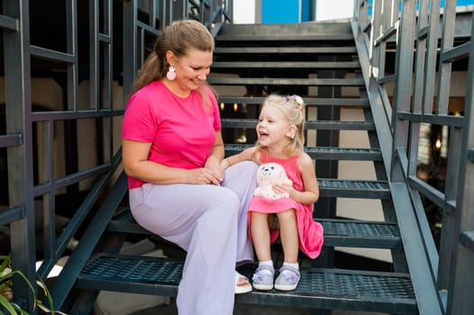 Child girl with cochlear implant with her mother spend time outdoor. Hear impairment and deaf community concept. Deaf and health concept. Diversity and inclusion. Copy space.