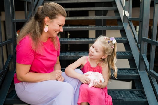 Child girl with cochlear implant with her mother spend time outdoor. Hear impairment and deaf community concept. Deaf and health concept. Diversity and inclusion. Copy space.