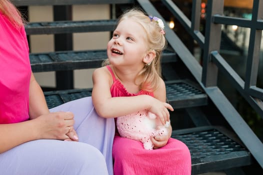 Child girl with cochlear implant with her mother spend time outdoor. Hear impairment and deaf community concept. Deaf and health concept. Diversity and inclusion. Copy space.