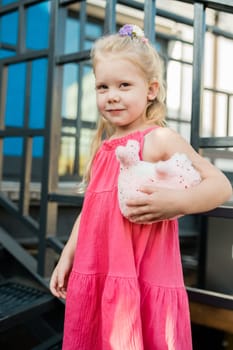 Child girl with hearing aids and cochlear implants having fun outdoor speak and playing. Copy space and empty place for advertising.