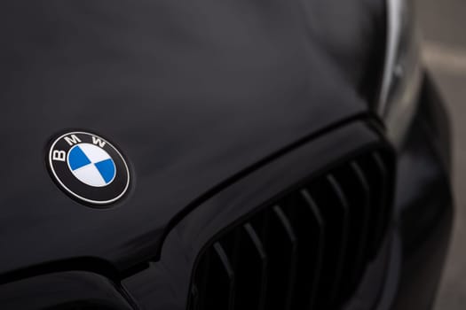 Closeup of BMW logo and grill on black car front. BMW 5-series. High quality photo