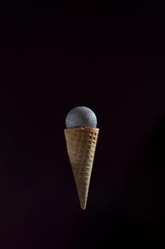 A microphone is placed inside of an ice cream cone. The cone is upside down and the microphone is suspended in the air