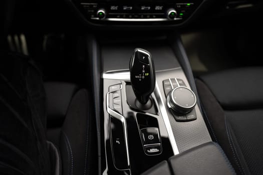 Automatic gear stick of modern car, multimedia and navigation control buttons. Car interior details. Transmission shift. High quality photo