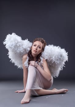 Studio photo of sad woman in guardian angel costume