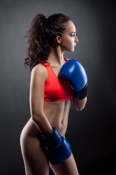 Nude. Beautiful young woman posing in boxing gloves