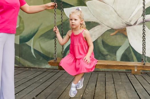 Child girl with hearing aids and cochlear implants having fun outdoor speak and playing. Copy space and empty place for advertising.