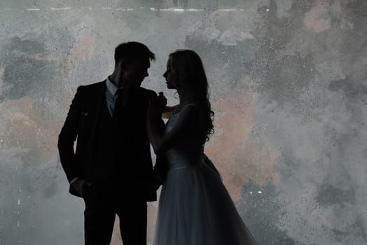 Art fashion studio photo of wedding couple silhouette groom and bride on colors background.