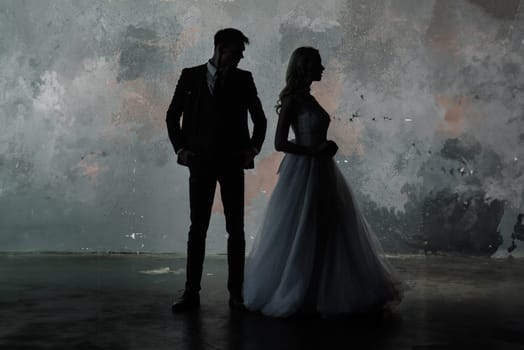 Art fashion studio photo of wedding couple silhouette groom and bride on colors background. Art Wedding style.