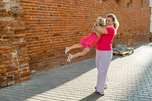 Child girl with cochlear implant with her mother spend time outdoor. Hear impairment and deaf community concept. Deaf and health concept. Diversity and inclusion. Copy space.