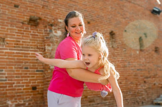 Child girl with cochlear implant with her mother spend time outdoor. Hear impairment and deaf community concept. Deaf and health concept. Diversity and inclusion. Copy space.