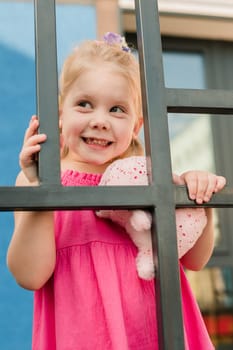 Happy cute child girl having fun outdoor in summer time. Children and generation alpha concept.